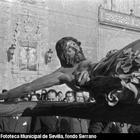 Traslado del Cristo de la Buena Muerte a la Fábrica de Tabacos con motivo del acto institucional de recepción de la nueva Universidad. El crucificado pasa junto al azulejo de la plaza de la Encarnación inaugurado en 1953. La Hermandad se instalará definitivamente en la nueva capilla en noviembre de 1966. 4 de abril de 1954 ©ICAS-SAHP, Fototeca Municipal de Sevilla, fondo Serrano