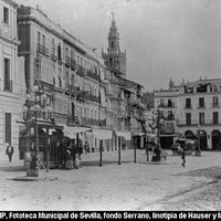 La inauguración de la línea de tranvías llamados de sangre tirados por mulas se efectúa el 5 de septiembre de 1887. La Compañía de Tranvías de Sevilla, tras unos años de intenso trabajo, puso en funcionamiento coches con pequeñas ruedas de hierro guiadas por raíles y una capacidad para dieciocho viajeros. La Pila del Pato, trasladada en 1850 a la Alameda de Hércules, ha dado paso a unas farolas en forma de gran candelabro con diez brazos y amplia base con figuras de sirenas, procedentes de la sevillana Fundición San Antonio. [1890-1892]. © ICAS-SAHP, Fototeca Municipal de Sevilla, fondo Serrano, linotipia de Hauser y Menet 