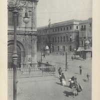 Vista de la entonces denominada plaza de la Constitución desde la embocadura de la Avenida. Una reja metálica, colocada en 1891 y desaparecida en 1919, rodeaba la fachada para evitar posibles destrozos en el edificio municipal. 1904.  ©ICAS-SAHP, Biblioteca del SAHP, álbum “Sevilla”, linotipia Hauser y Menet 