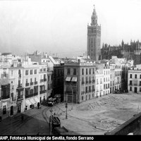 Desde finales del siglo XIX la evolución de la plaza avanzaba sin tregua.  Toca ahora el derribo de la Lonja de los Genoveses para la construcción del futuro Banco de España. Sorprende la visión del solar que deja reparar en las escasamente conocidas calles Cabo Noval y Felipe Pérez. Las obras se ralentizaron por motivos económicos en una ciudad volcada por entonces en otro tipo de edificaciones directamente vinculadas a la Exposición Iberoamericana de 1929. 1917.  ©ICAS-SAHP, Fototeca Municipal de Sevilla, fondo Serrano