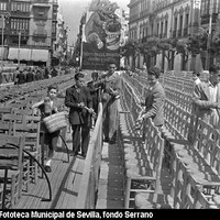 Los palcos de la plaza de la Falange Española, denominada así de 1936 hasta 1980, constituyen el centro neurálgico de la Carrera Oficial en Semana Santa y un escenario idóneo para la publicidad de la marca de desinfectante Orión. 1946.  ©ICAS-SAHP, Fototeca Municipal de Sevilla, fondo Serrano