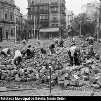 Con la desaparición del último tranvía que circuló por las calles de la ciudad, el Ayuntamiento de Sevilla se afana en desmantelar la mayoría de las traviesas de los raíles que durante años dibujaban el asfalto del centro urbano, así como en el adecentamiento del pavimento original de la plaza con los tradicionales adoquines de cantera. 1960.  ©ICAS-SAHP, Fototeca Municipal de Sevilla, fondo Gelán