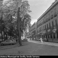 Fachada del hotel Cécil-Oriente en la Plaza Nueva. En el edificio contiguo, el único primitivo que se mantiene, subsiste embutida la capilla de San Onofre, resto del antiguo convento de San Francisco. Enfrente, se ha habilitado espacio para aparcamientos. ca. 1960. ©ICAS-SAHP, Fototeca Municipal de Sevilla, fondo Serrano