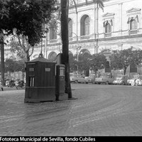 Surtidor de gasolina de la Campsa, uno de los seis ubicados en el centro histórico para dar servicio a un todavía reducido parque móvil. Motocicletas y coches aparcados. 1961. ©ICAS-SAHP, Fototeca Municipal de Sevilla, fondo Cubiles