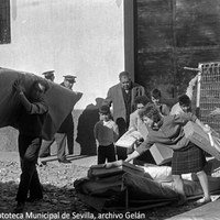 16. Las familias afectadas, como estos vecinos de La Corza, retiran camas, colchones y otros enseres suministrados por la Junta de Trabajo y Reparto. 11 de diciembre de 1961 ©ICAS-SAHP, Fototeca Municipal de Sevilla, archivo Gelán